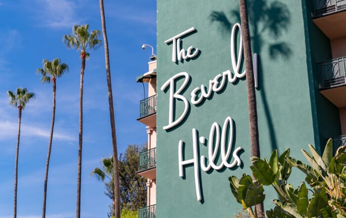 The Beverly Hills Hotel building in Beverly Hills, California, with palm trees growing beside it.