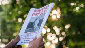 Missing Persons Alert Flyer - Kay And Associates A Missing Persons Poster being held by a person's hands.